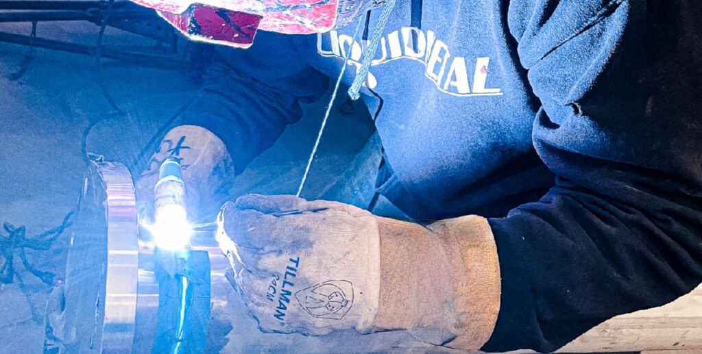 Man Welding at Liquid Metal Coatings Hero Banner